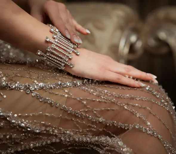 A woman adorned in diamond jewelry and an embellished dress